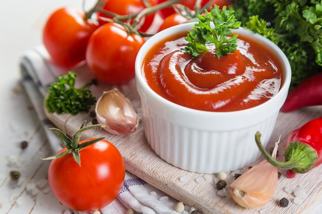 Ketchup et ingrédients sur fond de bois