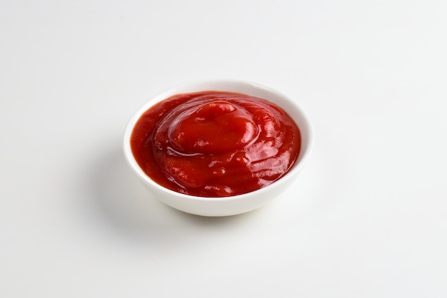 Ketchup en plaque blanche sur fond blanc.