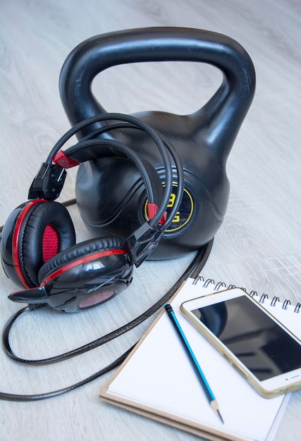 Kettlebell de gymnastique avec casque de musique et carnet pour enregistrer les résultats des sports actifs