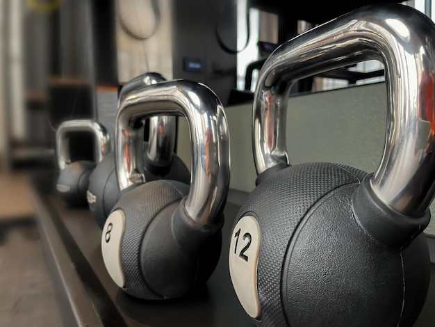 Des kettlebells noirs de 12 kg sur l'étagère de la salle d'entraînement.