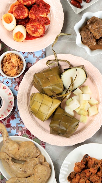 Ketupat Lebaran Plat de fête traditionnel de gâteau de riz ou Ketupat avec divers plats d'accompagnement populaires servis pendant les célébrations de l'Aïd pour la bannière des médias sociaux