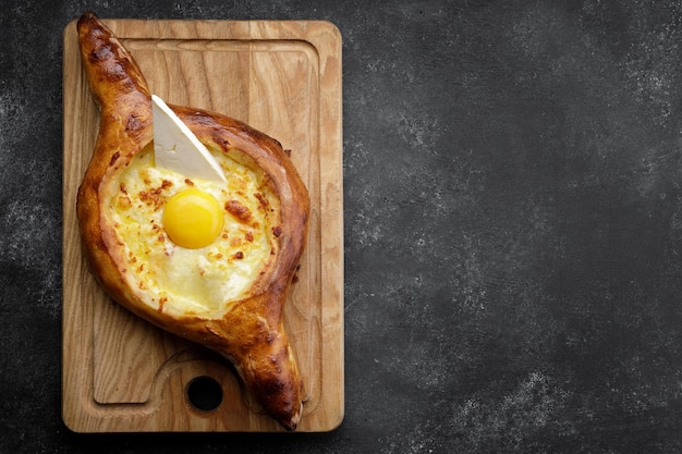 Khachapuri adjar sur une planche de bois