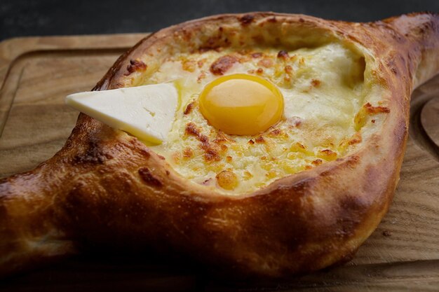 Khachapuri adjar sur une planche de bois