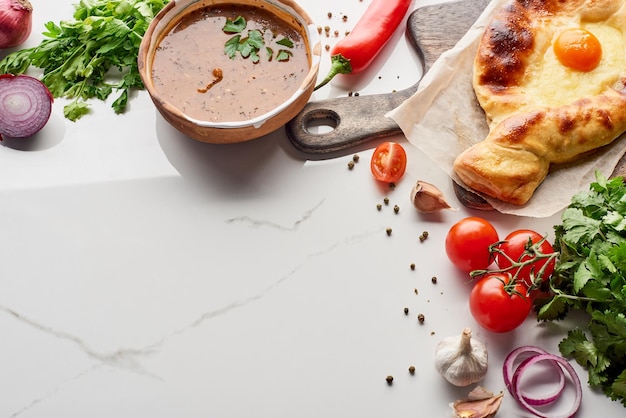 Khachapuri d'Adjarie et kharcho de soupe aux légumes sur la texture de marbre