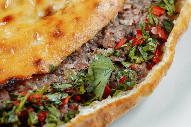 Khachapuri géorgien avec de l'agneau et des piments sur la table en bois