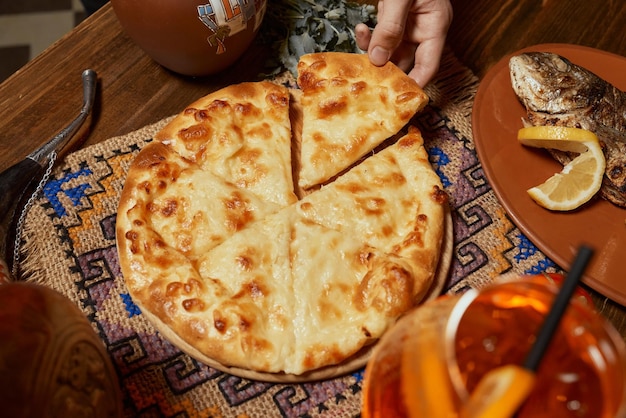 Khachapuri sur la main féminine vue de dessus de table