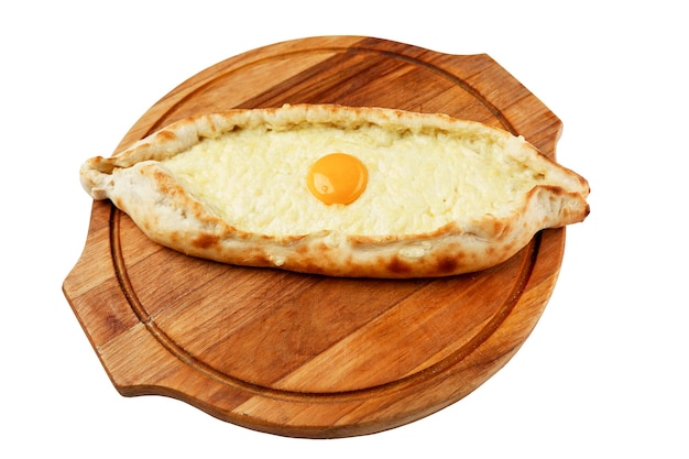 Khachapuri avec oeuf sur une planche de bois plat traditionnel de la cuisine géorgienne isolé sur fond blanc