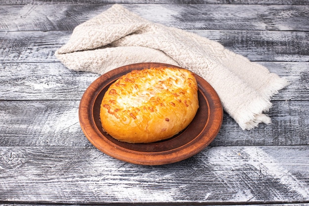 Khachapuri avec saucisse sur une plaque en bois de fond en bois blanc