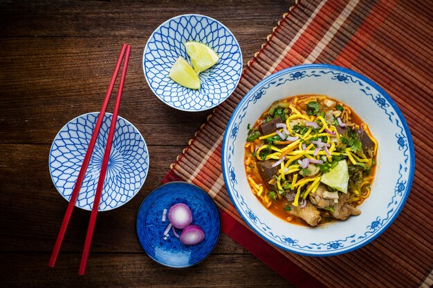 Photo khao soi - cuisine thaïlandaise traditionnelle, khao soi soupe thaï aux nouilles au curry avec poulet