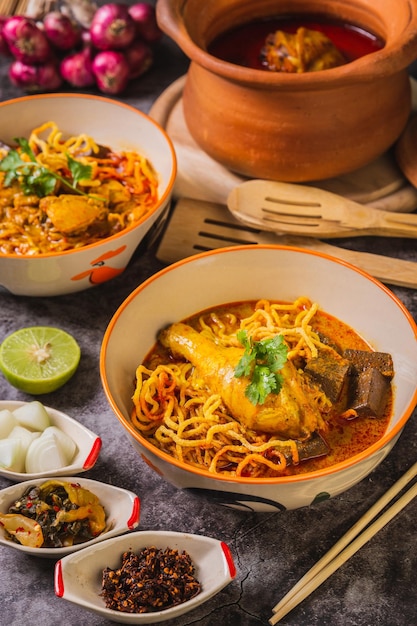 Khao Soi KaiDélicieuse cuisine du nord de la ThaïlandeArrangée avec des assaisonnements sur la table