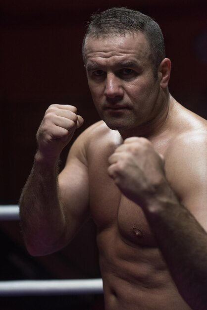 kickboxer professionnel avec les mains en position d'arts martiaux s'entraînant pour le combat dans le ring d'entraînement