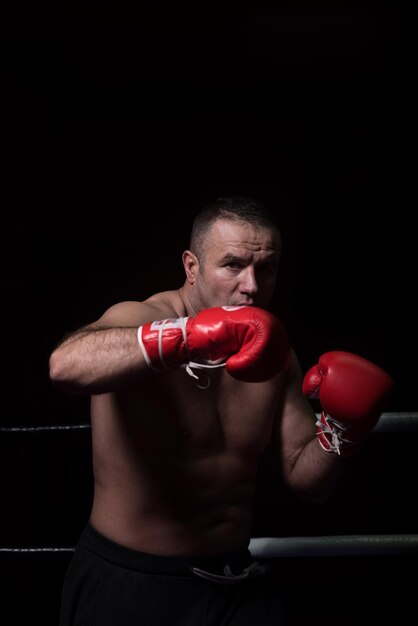 kickboxer professionnel avec les mains en position d'arts martiaux s'entraînant pour le combat dans le ring d'entraînement