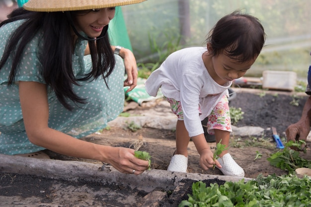 Kid aide sa mère à planter les graines dans la ferme