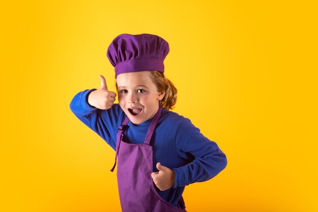 Kid chef cuisinier prépare la nourriture sur fond de studio isolé