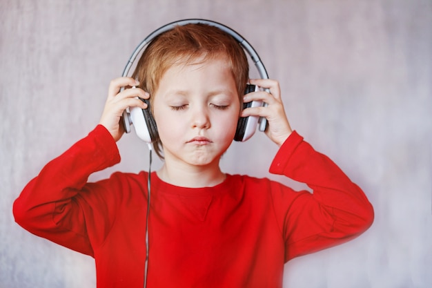 Kid écouter de la musique à la maison. Enfant avec un casque.