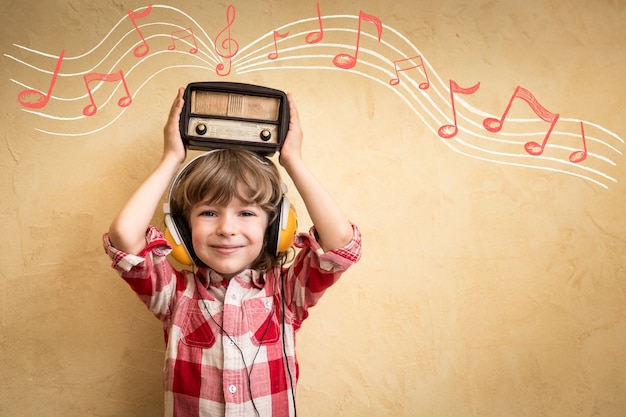 Kid écouter de la musique à la maison. Enfant hipster avec radio vintage rétro