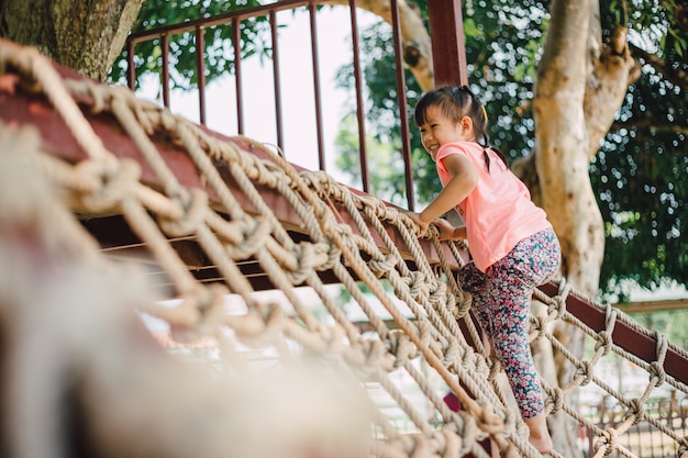 Kid escalade la corde dans la cour de récréation