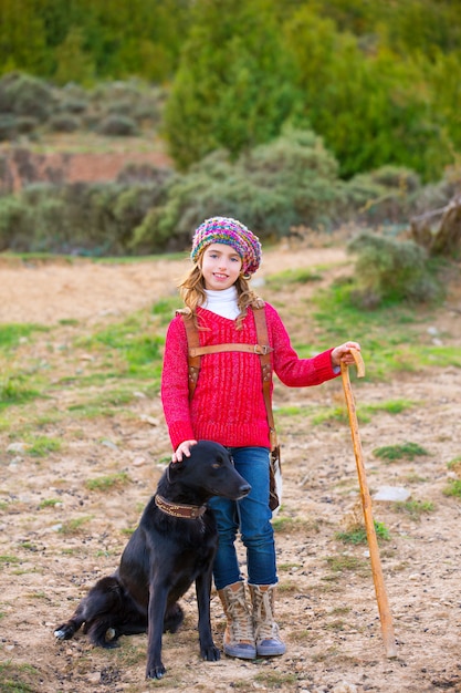 Kid fille bergère heureuse avec chien et troupeau de moutons