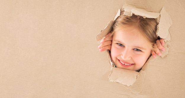 Kid fille regardant à travers le trou dans la boîte