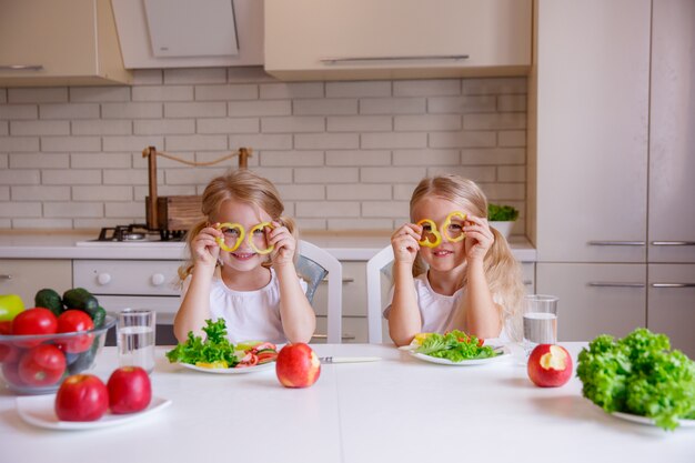 Kid fille s'amusant avec des légumes alimentaires à la cuisine, les enfants mangent des aliments sains dans la cuisine