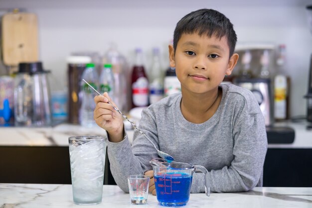 Kid garçon faisant le mélange eau bleu hawaii