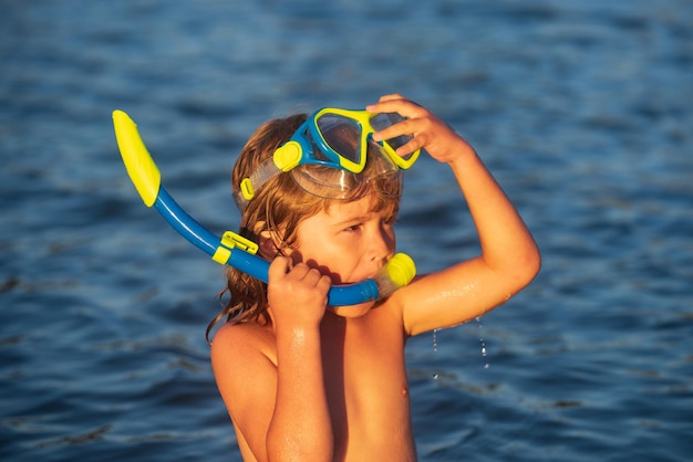 Kid garçon plongée en apnée sur la plage sur la mer bleue en été. Océan bleu avec wawes. Enfant garçon nageant en mer.