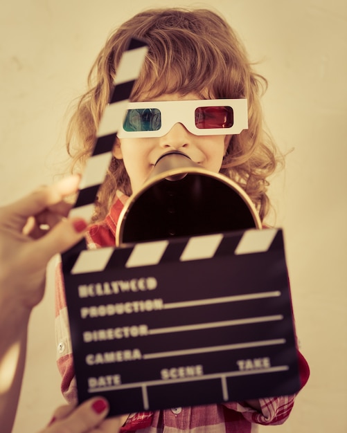 Kid holding clapper board dans les mains. Notion de cinéma. Style rétro