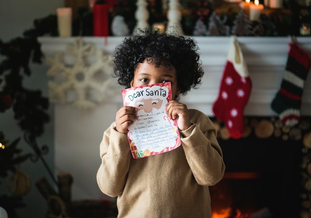 Kid avec la liste de souhaits de Noël