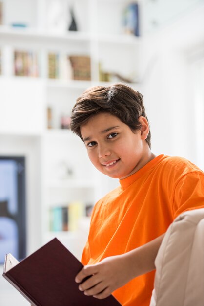 Kid avec livre à la maison