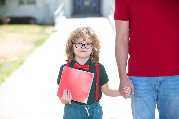 Kid nerd school family education et concept de plein air parent tenant la main de son fils avec sac à dos outdoo