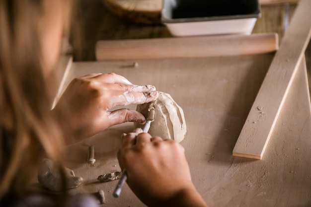 Kid sculpte de l'argile. Gros plan des mains