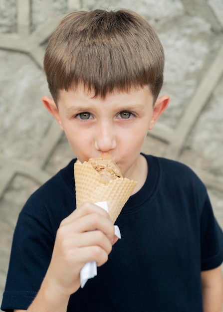 Kid shot moyen mangeant de la crème glacée