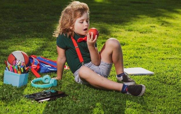 Kid sitting outdoor in garden eating apple petit enfant l'éducation scolaire en plein air sur la distance en ligne lea