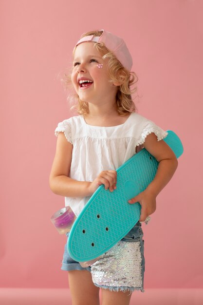 Photo kid smiley de coup moyen tenant pennyboard