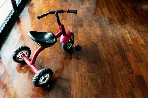 Kid vélo sur le plancher en bois