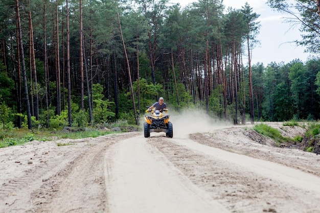 Kiev Septembre 2019 Homme monté sur un véhicule tout terrain Quad ATV jaune sur une forêt de sable de sport extrême motion aventure attraction touristique