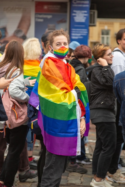 Kiev, Ukraine - 19.09.2021 : communauté LGBTQ au défilé de la fierté. La fille est enveloppée dans un drapeau arc-en-ciel pendant la marche.