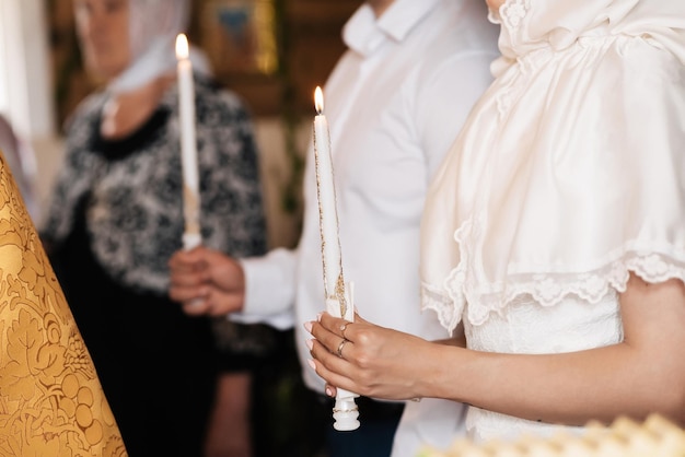 KINESHMA RUSSIE 12 JUIN 2020 les mains de la mariée avec une bougie lors de la cérémonie de mariage chrétienne à l'église