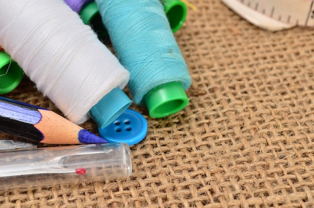 Kit De Couture. Ciseaux, Bobines Avec Fil Et Aiguilles Sur Le Vieux Tissu