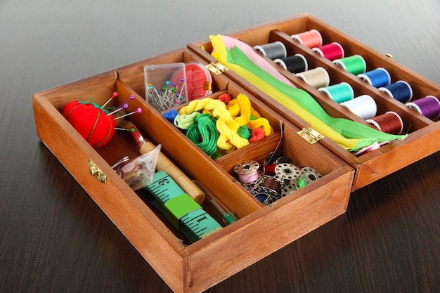 Kit de couture dans une boîte en bois sur une table en bois