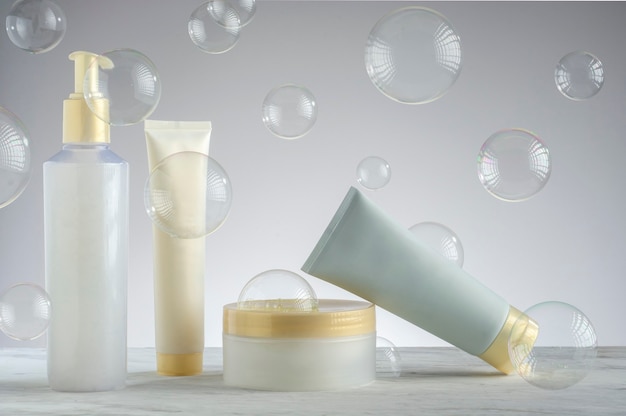 Photo kit d'emballage de crème de soin de la peau avec des bulles de savon sur le fond