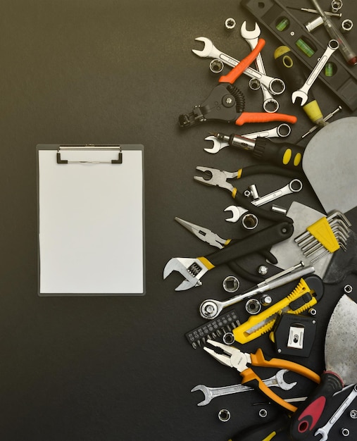 Kit d'outils de bricolage sur table en bois noir de nombreuses clés et tournevis piles et autres outils pour