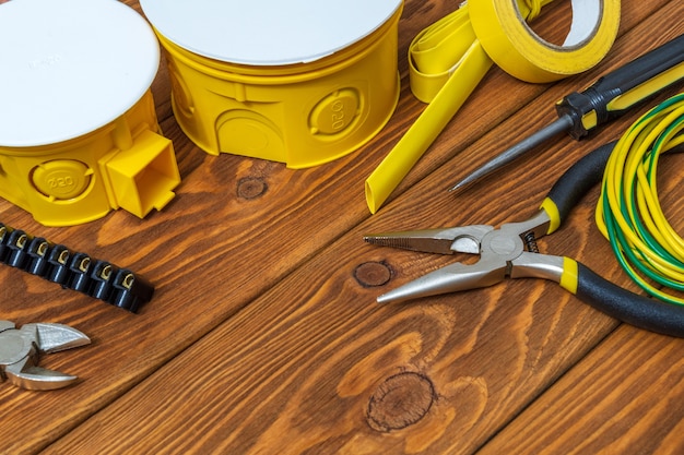 Kit de pièces détachées jaune pour l'électricité et un outillage préparé sur des planches en bois vintage avant réparation ou réglage