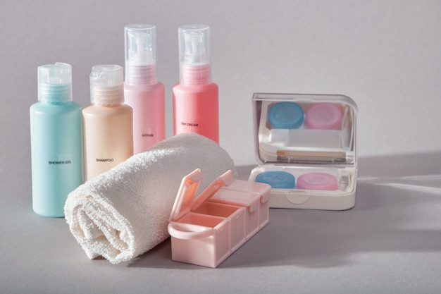 Kit de voyage. Ensemble de quatre petites bouteilles en plastique pour produits cosmétiques, kit pour lentilles de contact, organisateur de pilules, serviette.