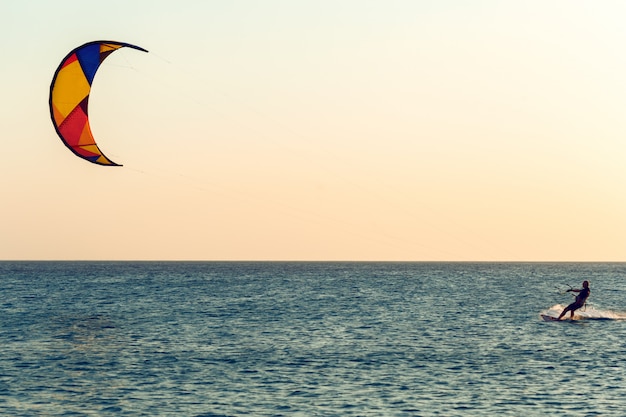 Kitesurf au coucher du soleil en mer