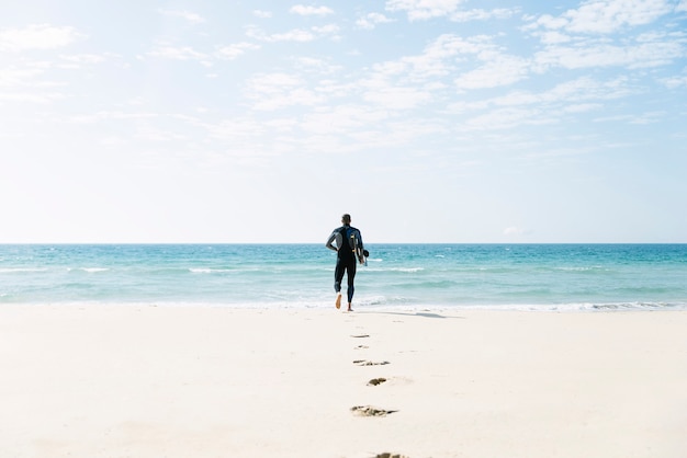 Kitesurfer bel homme courant dans la plage.