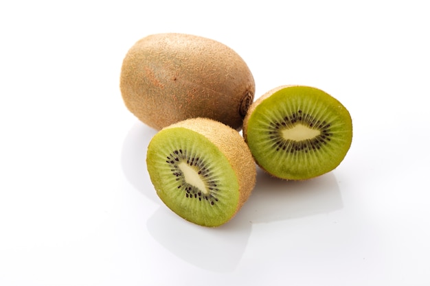 Kiwi entier et ses segments tranchés sur fond blanc