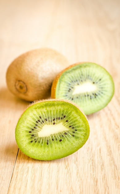 Kiwi sur le fond en bois: fruits entiers et coupe transversale