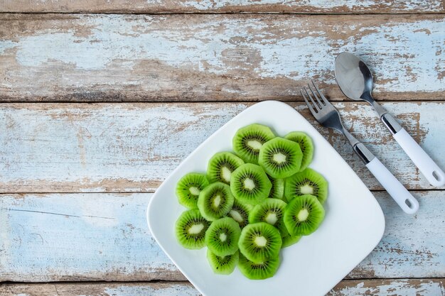 Photo kiwi frais dans une assiette sur une table en bois