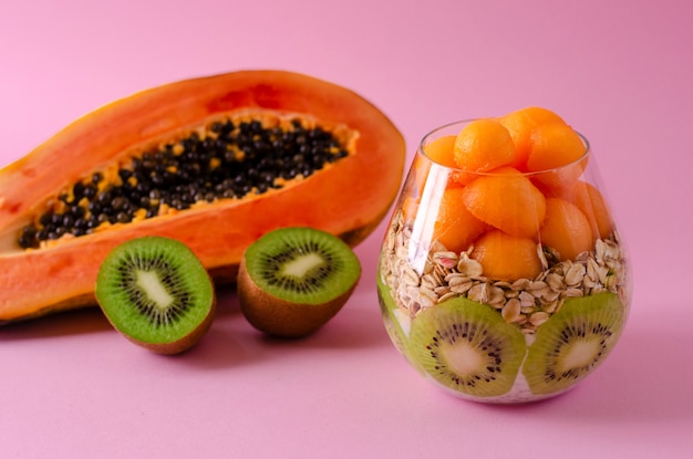 Kiwi frais, papaye et flocons d&#39;avoine pour un petit déjeuner sain sur le pourpre